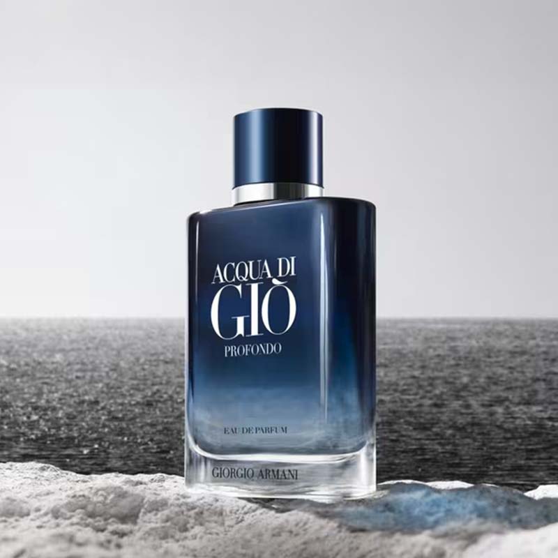 Giorgio Armani Acqua di Giò Profondo perfume bottle on a beach with ocean in the background