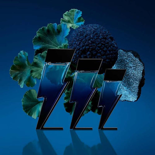 Carolina Herrera Fragrance Bottles surrounded by green leaves and a blue rock on a blue background