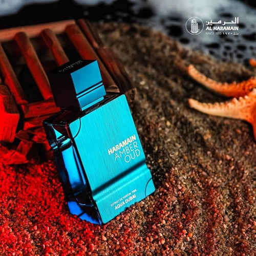 Al Haramain Amber Oud Aqua Dubai perfume bottle on beach sand with starfish and red lighting