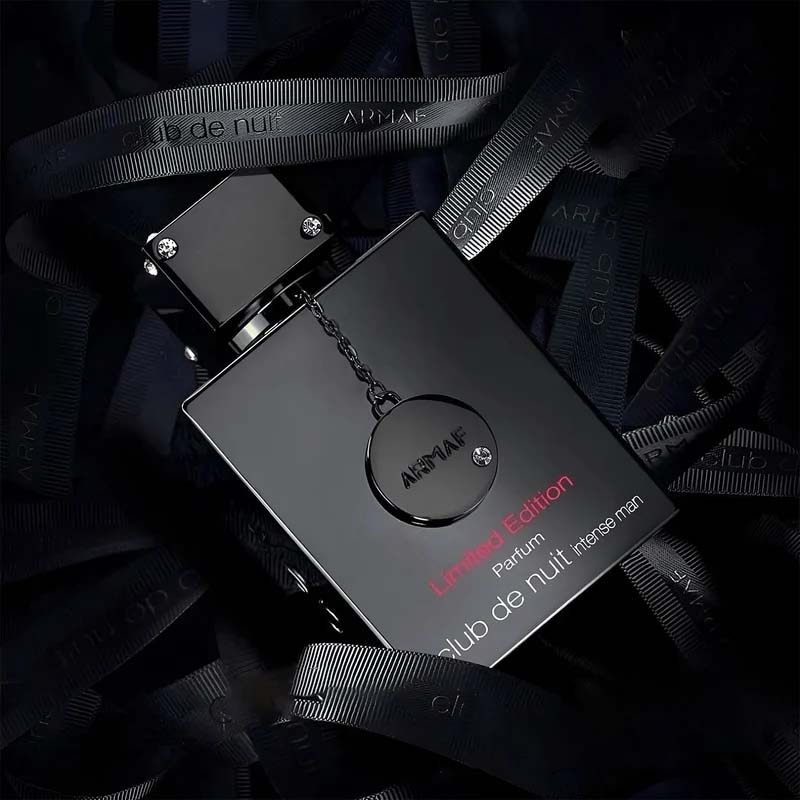 Armaf Club de Nuit Intense Man Limited Edition bottle with chain pendant on branded ribbon backdrop