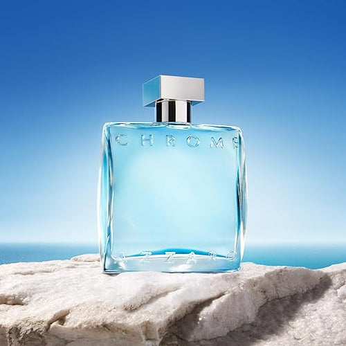 Azzaro Chrome Eau de Toilette bottle on white stone with ocean and blue sky background