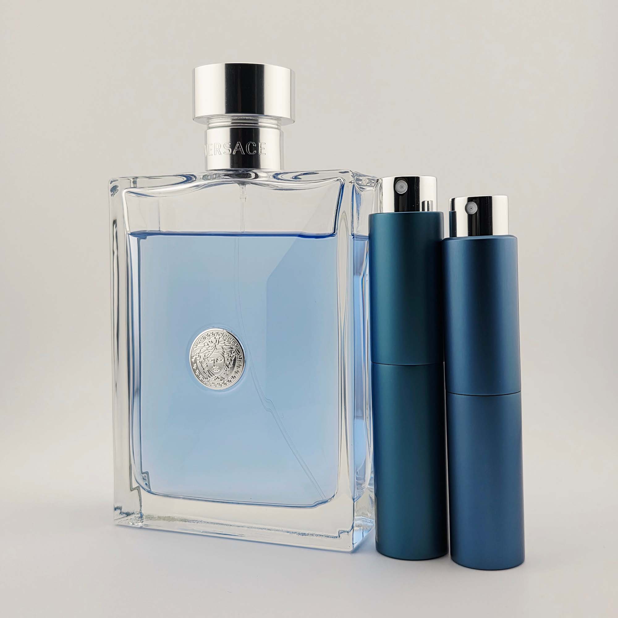 Versace Pour Homme bottle next to two blue travel-size decant atomizers, displayed on a light background for product detail emphasis.
